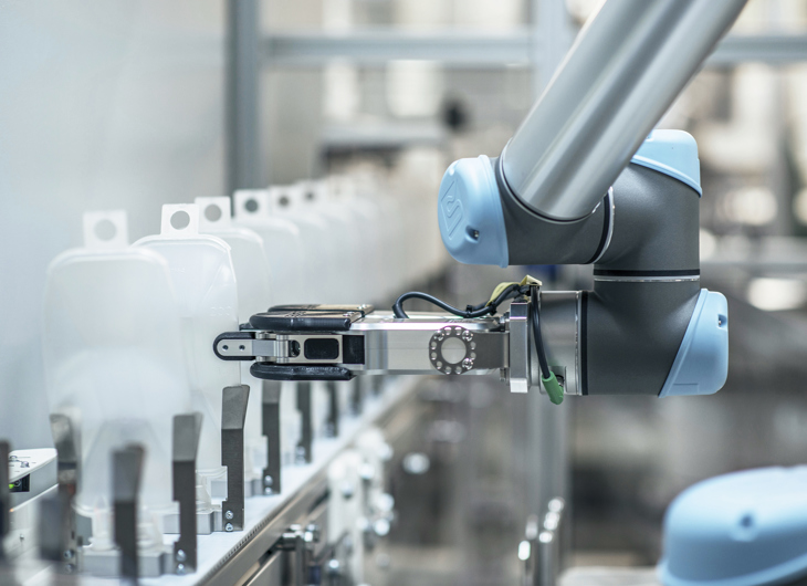 Robotarm, der automatiserer produktionslinjen, håndterer medicinsk emballage og forbedrer farmaceutisk effektivitet.